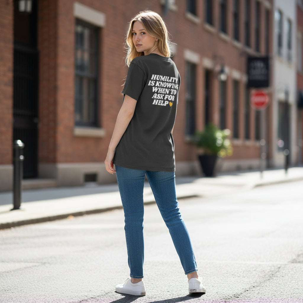 Woman wearing a black t-shirt with text on it, standing on a street.