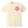 Beige t-shirt with 'God is all around us' text in pink on a white background