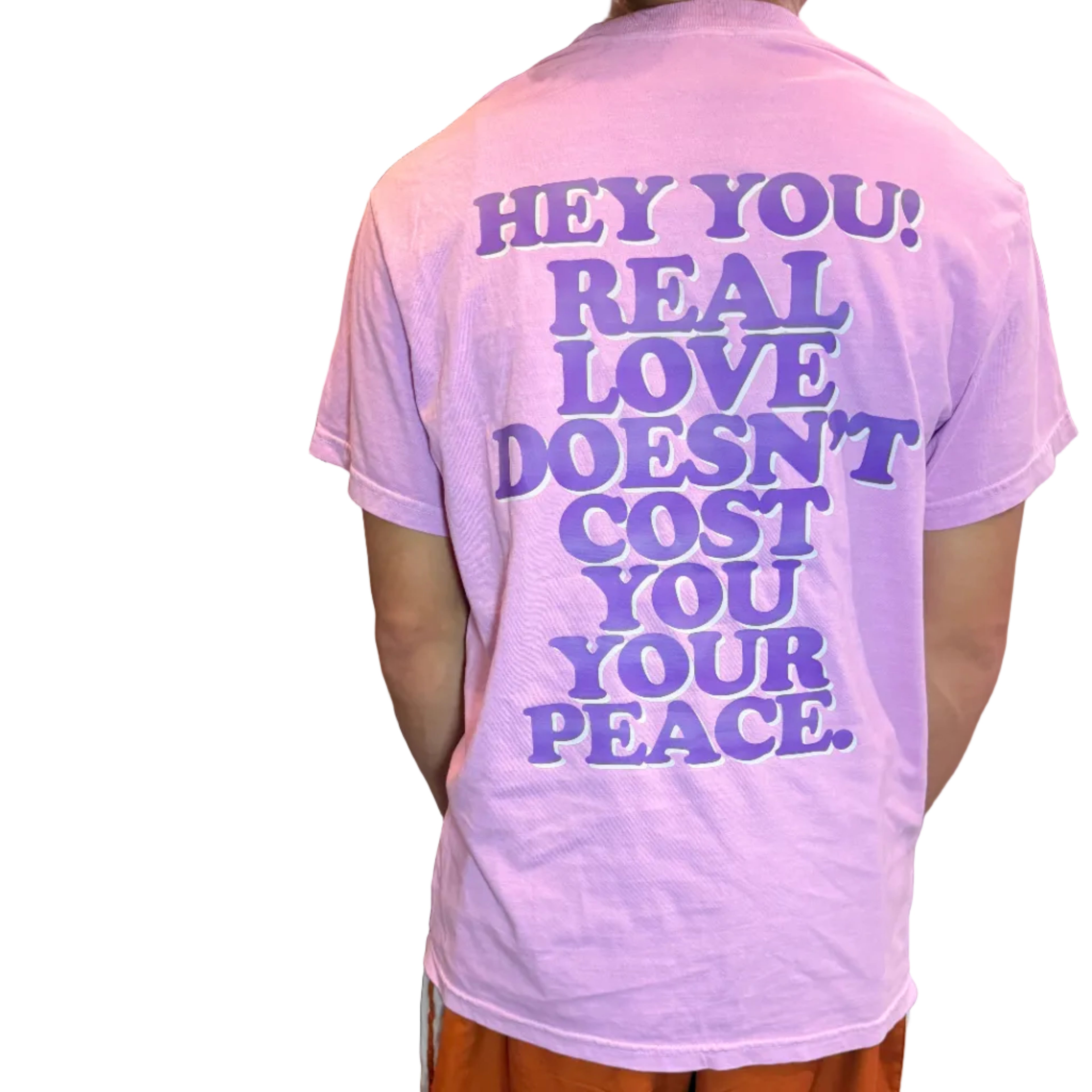 Person wearing a pink t-shirt with a motivational quote indoors.