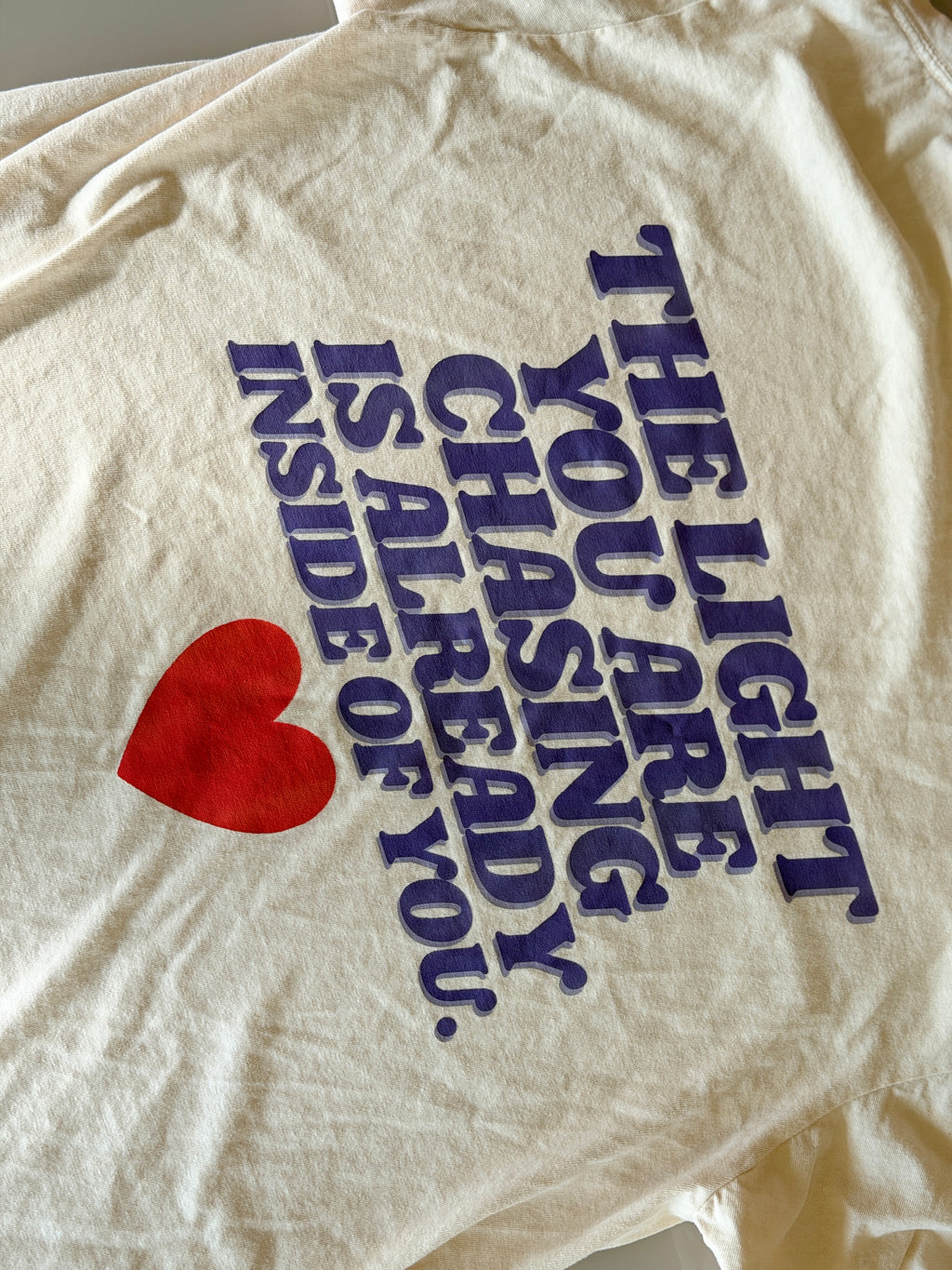 White t-shirt with motivational quote and red heart on a plain background