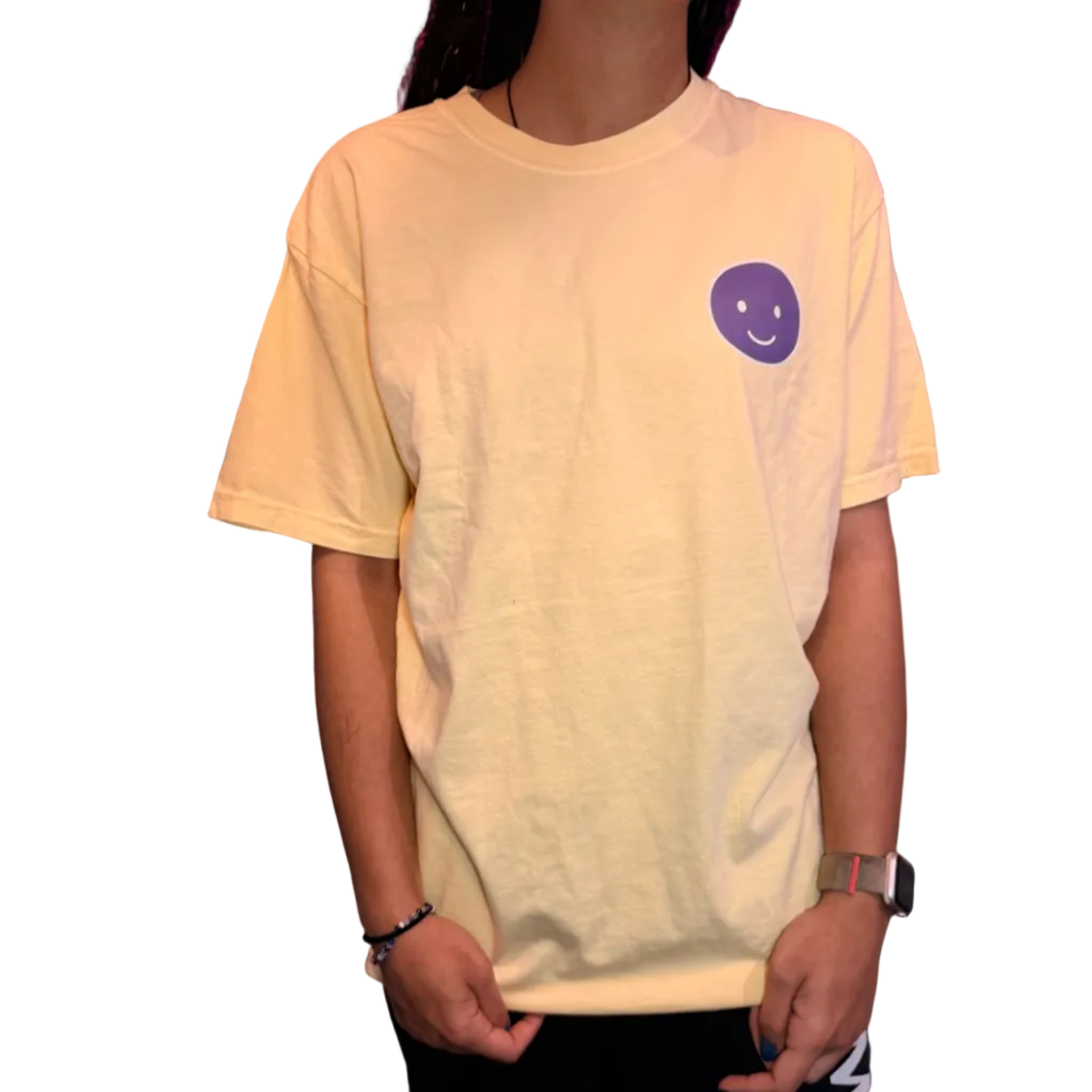 Person holding a light-colored shirt with a small logo on a dark surface