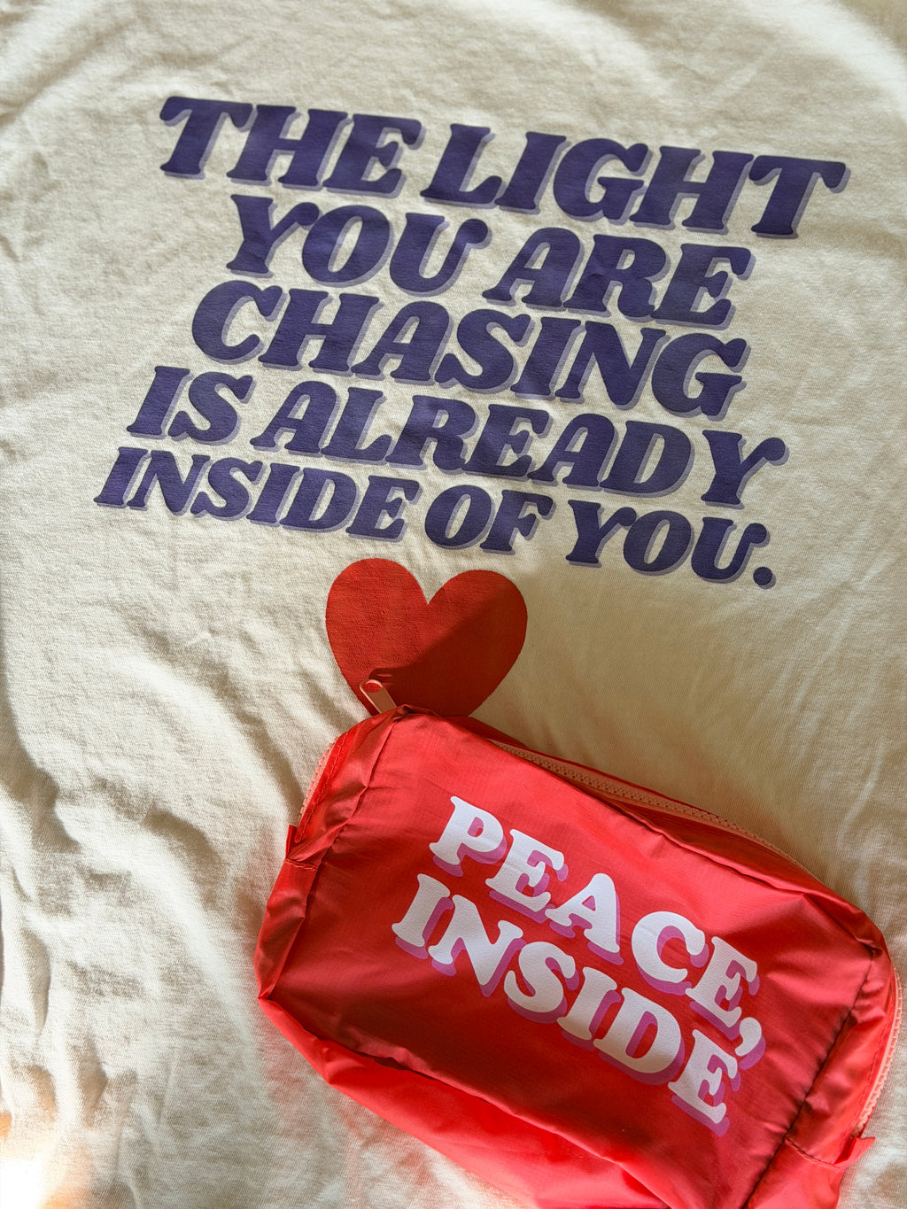 Beige t-shirt with motivational quote and red pouch with 'Peace Inside' text.
