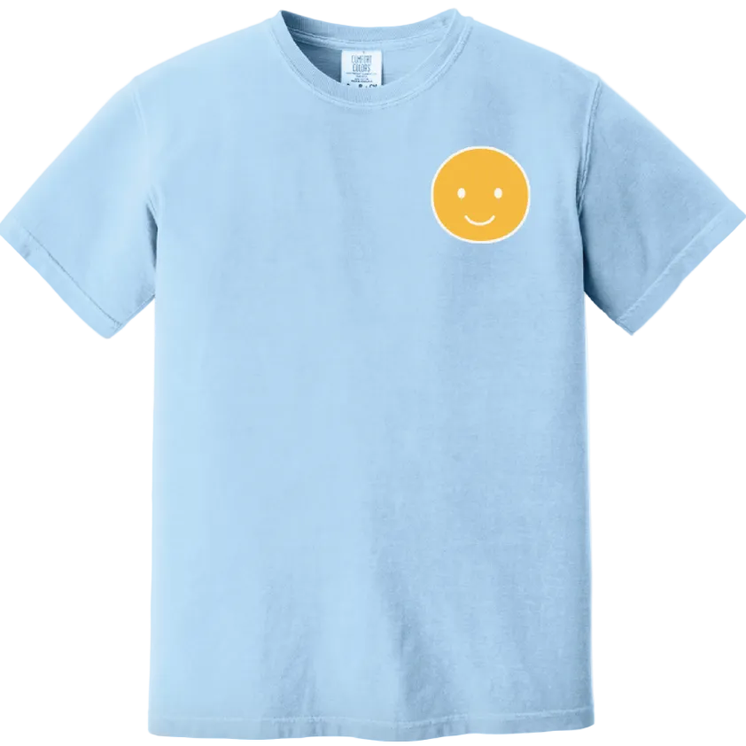 Light blue t-shirt with a yellow smiley face design on a white background