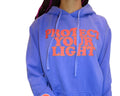 Person wearing a blue hoodie with text and a smiley face on a couch.