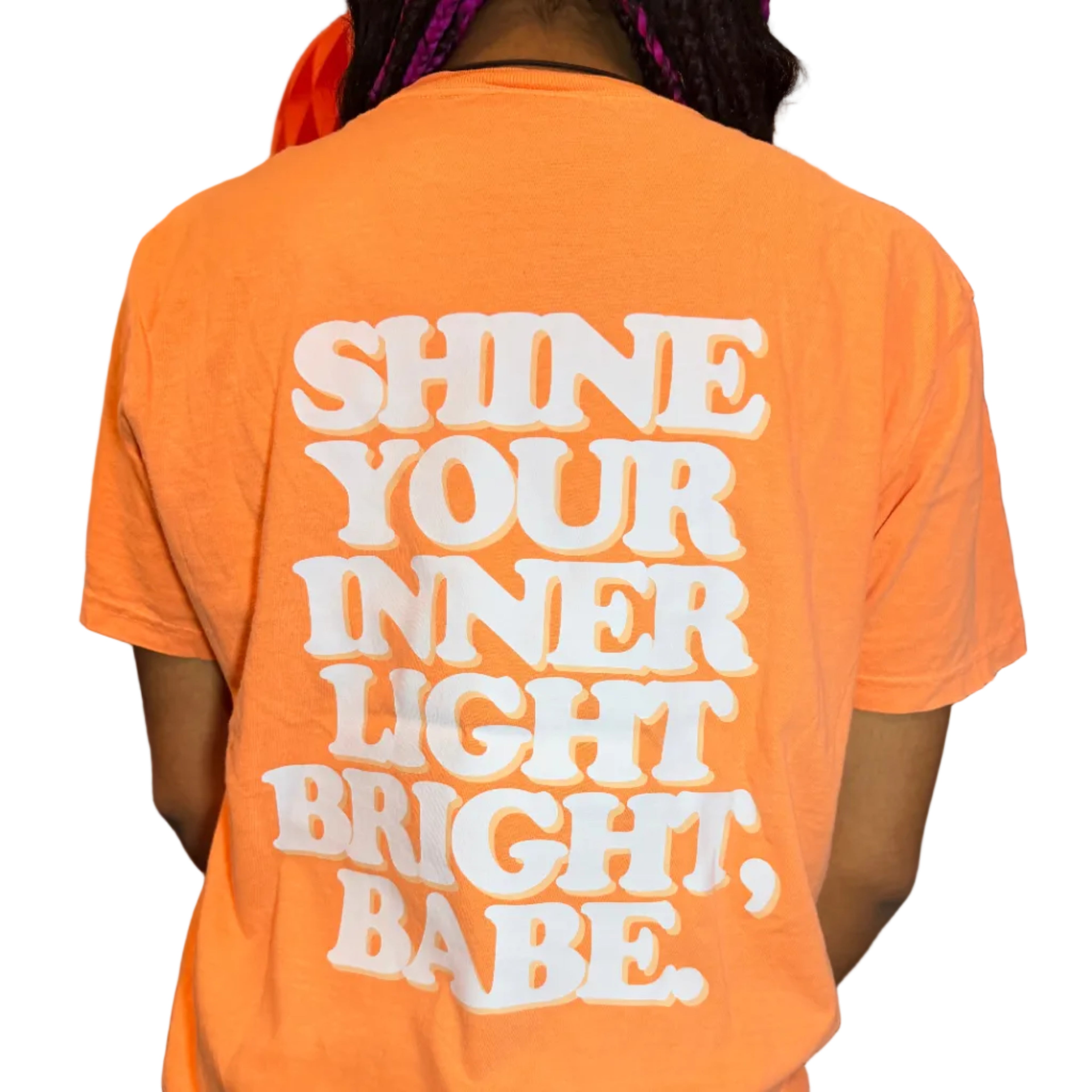 Person wearing an orange shirt with white text sitting on a chair.