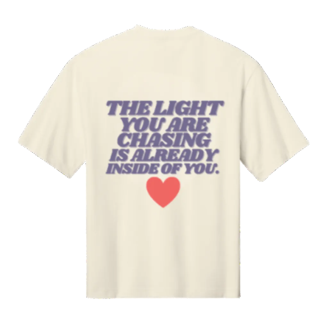 Beige t-shirt with motivational quote and heart graphic on a white background