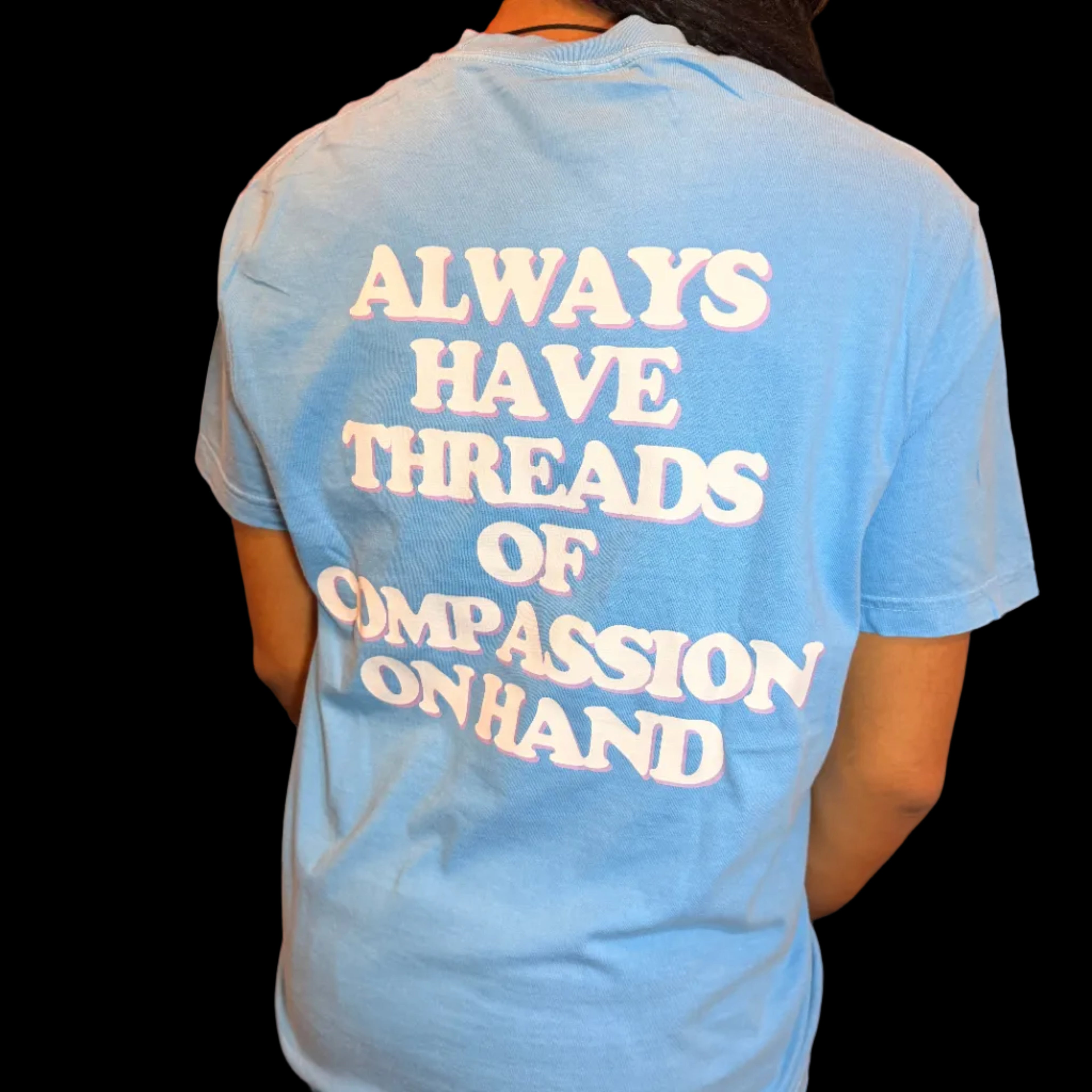 Person wearing a blue t-shirt with a motivational quote, sitting on a couch.