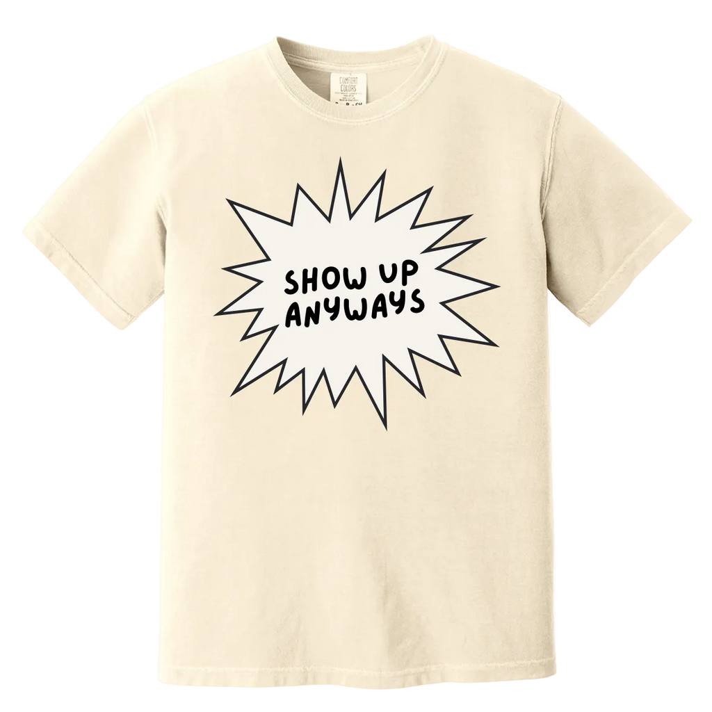 Beige t-shirt with 'Show Up Anyways' text on a white background